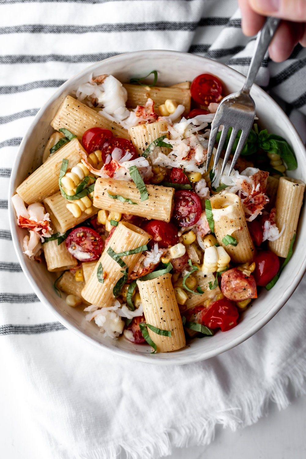 Succulent summer Maine lobster meat paired with cherry tomatoes, corn and tossed with rigatoni for a delicious summer pasta recipe