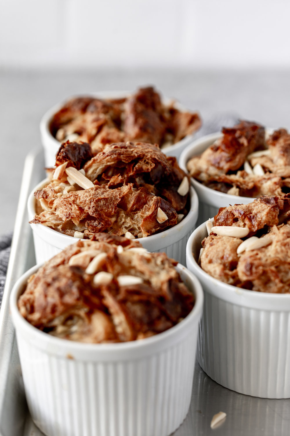 croissant bread pudding in individual ramekins with slivered almonds