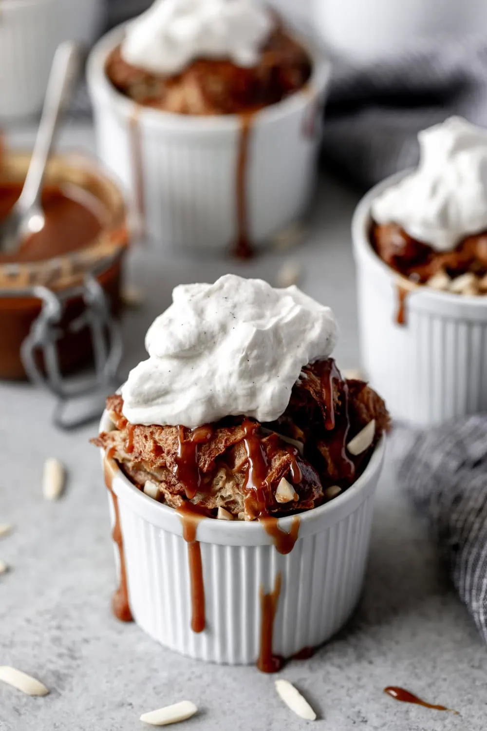 Individual Almond Croissant Bread Pudding recipe with whipped cream and caramel