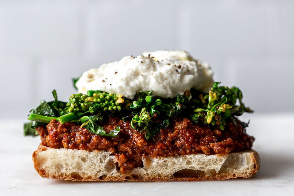 stacked sandwich ingredient shot ciabatta, bolognese, rapini, burrata