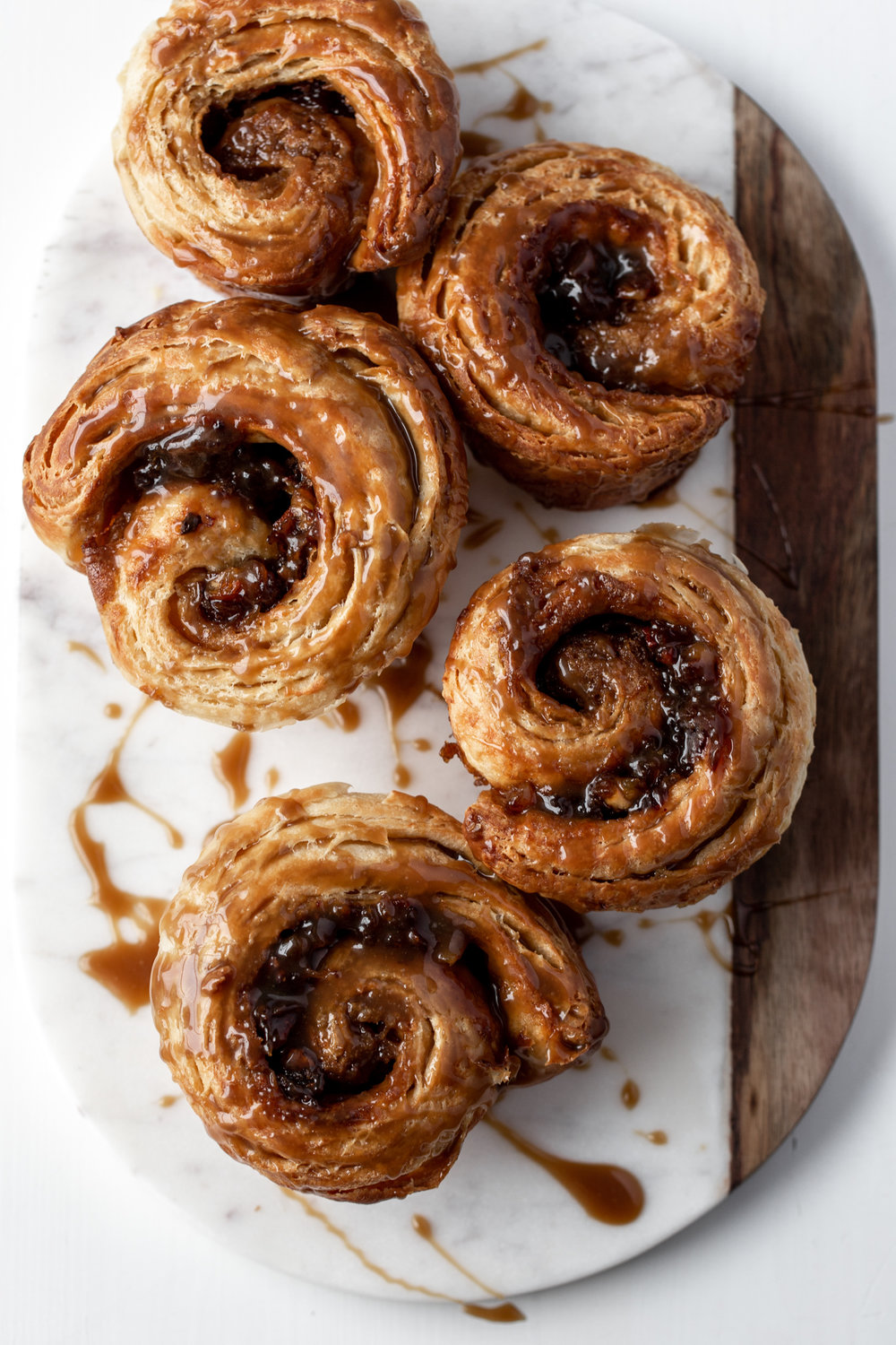 In this morning bun recipe inspired by sticky toffee pudding, croissant dough is stuffed with filling made with dates & baked in muffin tins.