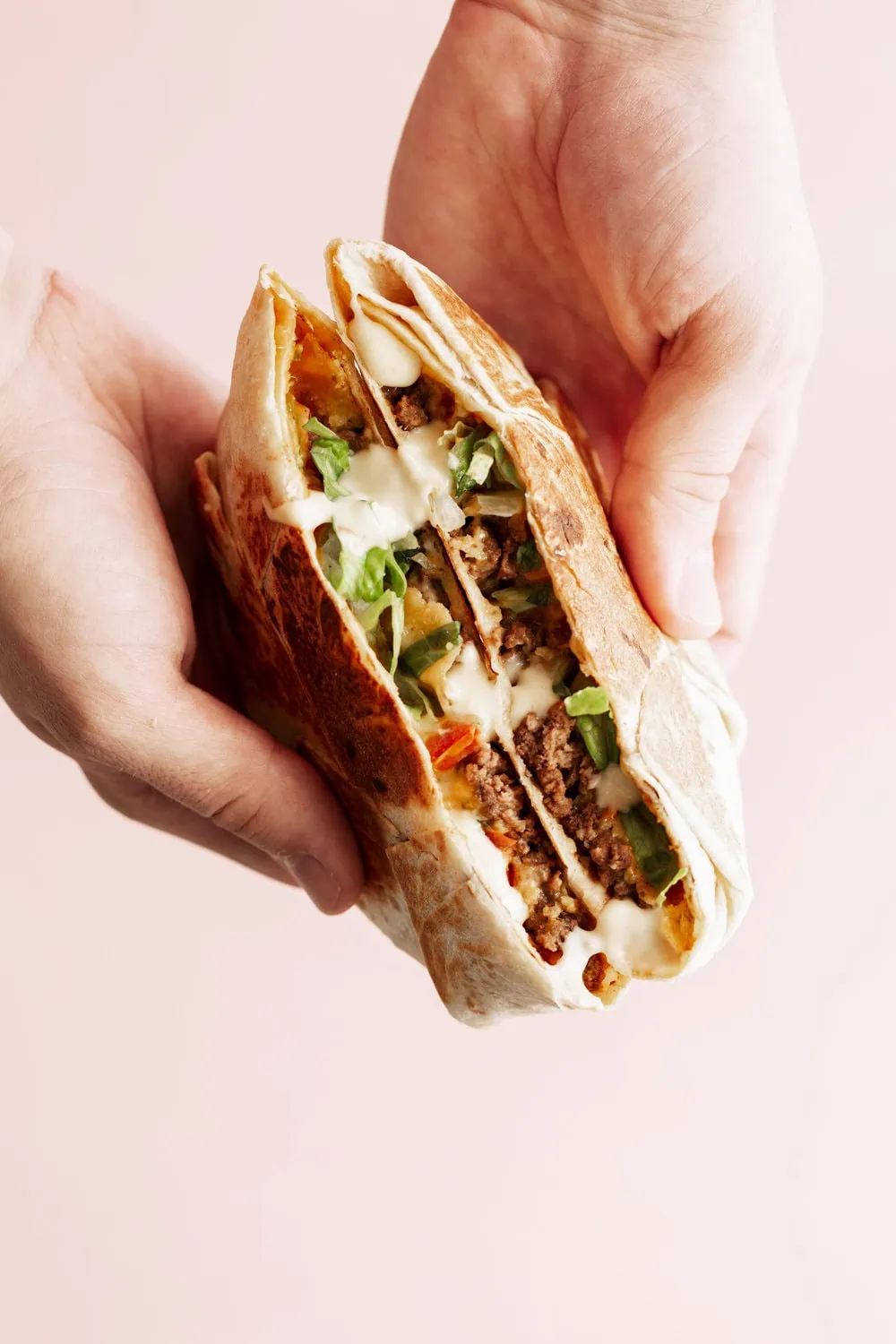 homemade crunch wrap supreme with ground beef and queso halved