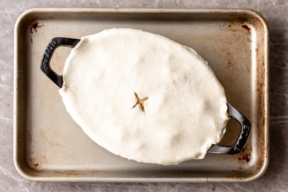 lobster pot pie topped with puff pastry dough in small staub baking dish