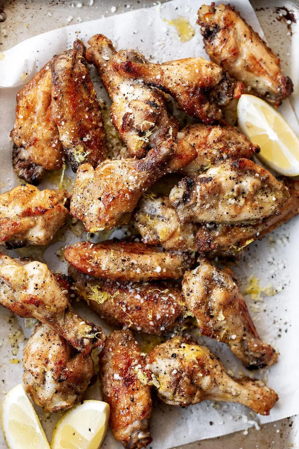 Baked Lemon Black Pepper Wings recipe with lemon zest and lemon wedges