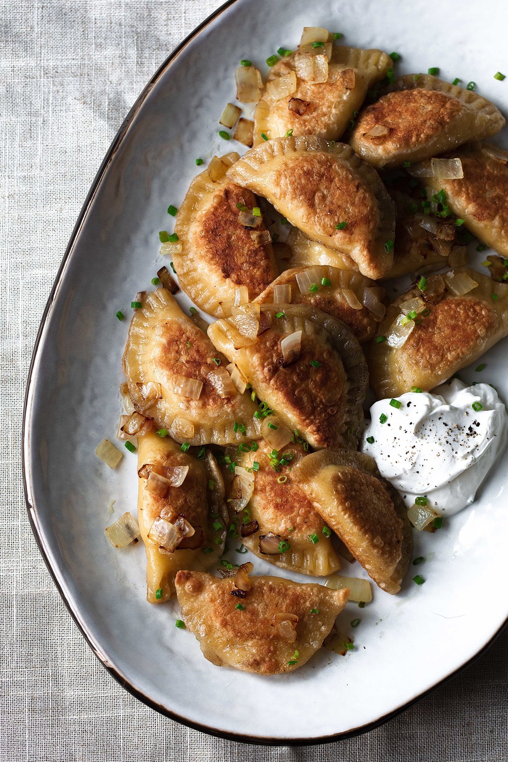 Potato and Cheese Pierogies recipe with grilled onions chives and sour cream