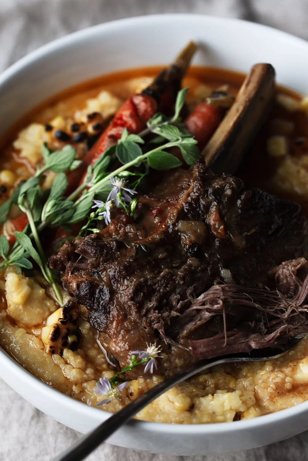 Chili Braised Short Ribs with Carrots and Charred Corn Polenta recipe from cooking with cocktail rings closeup