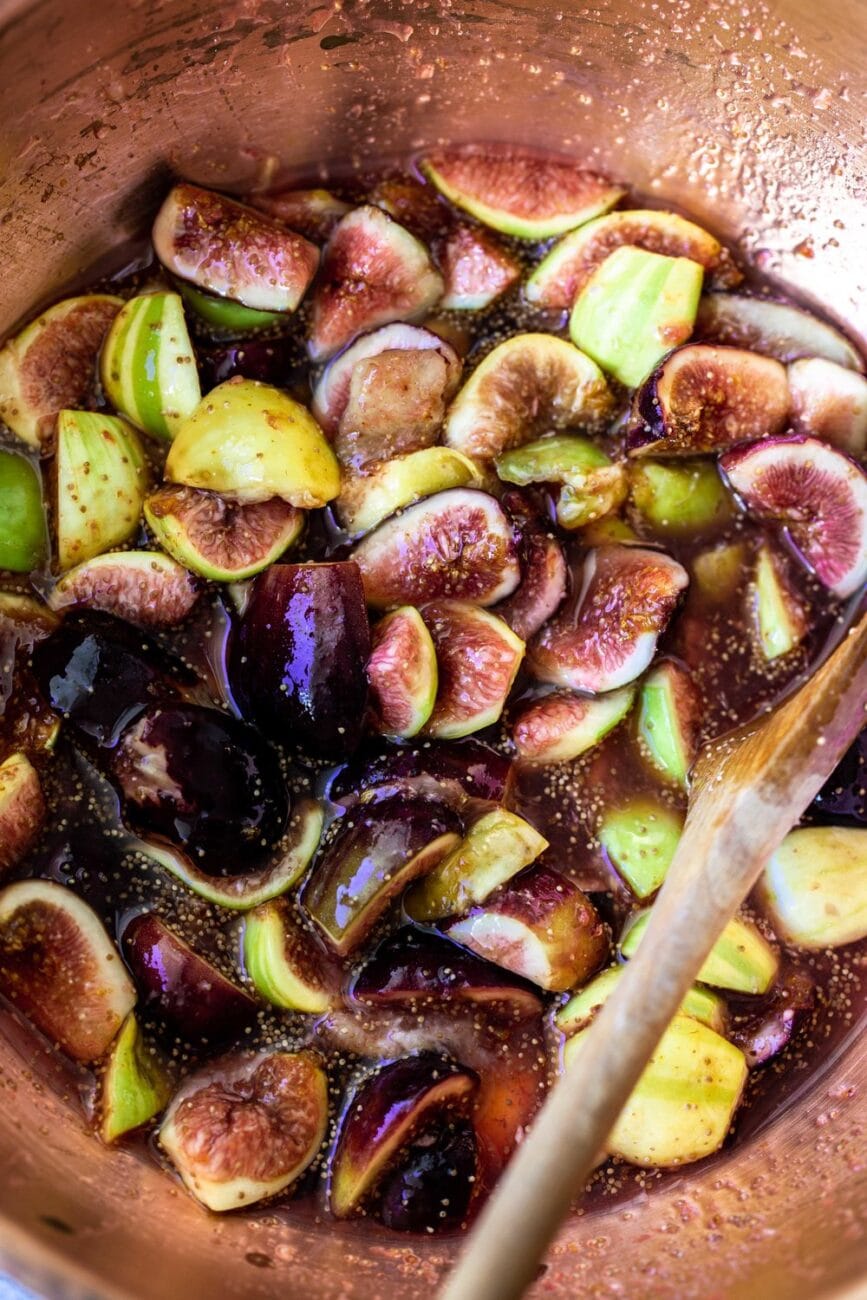 macerated figs in copper bowl with wooden spoon.