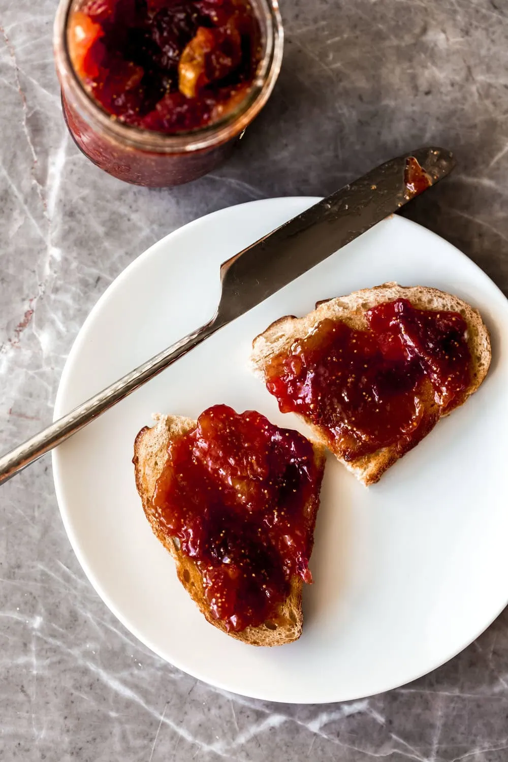 homemade fig jam on sourdough toast with knife on plate 
