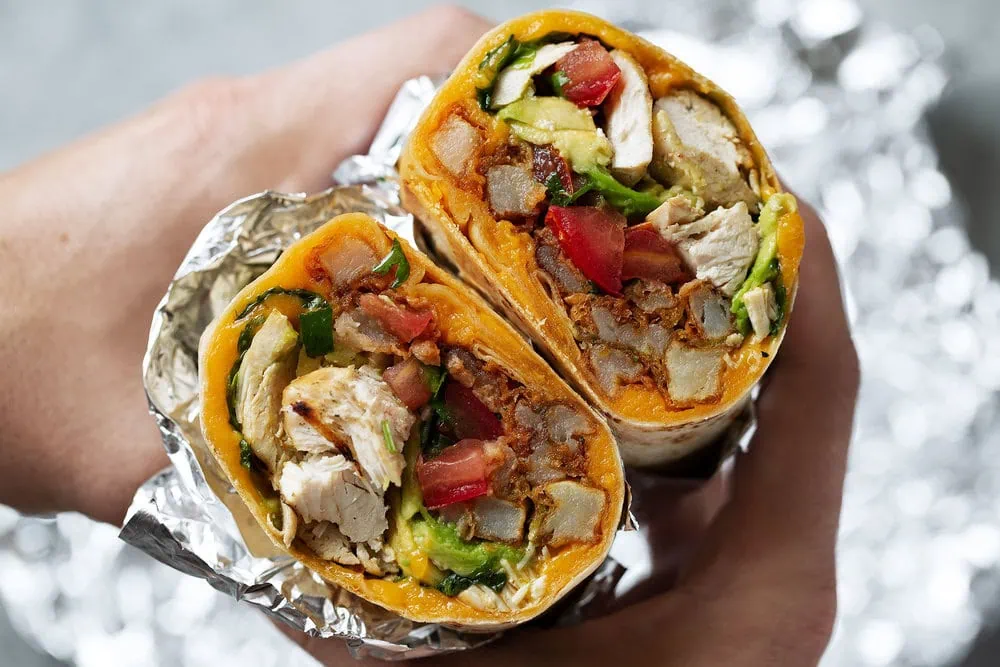 California chicken burrito with seasoned fries cooking with cocktail rings closeup cut