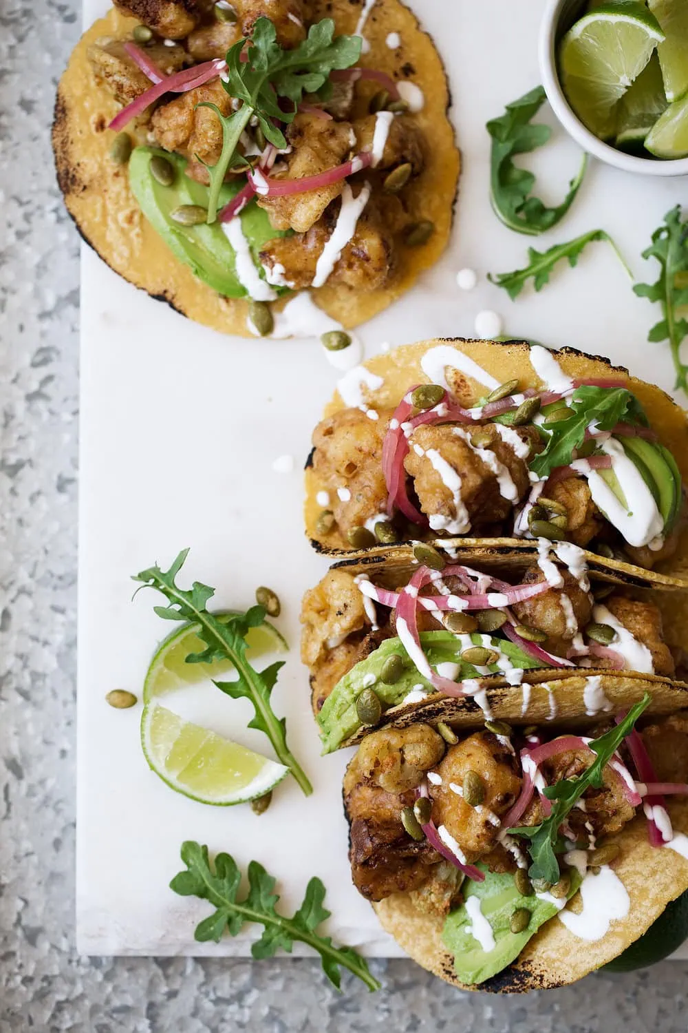 roasted cauliflower and avocado tacos recipe on marble