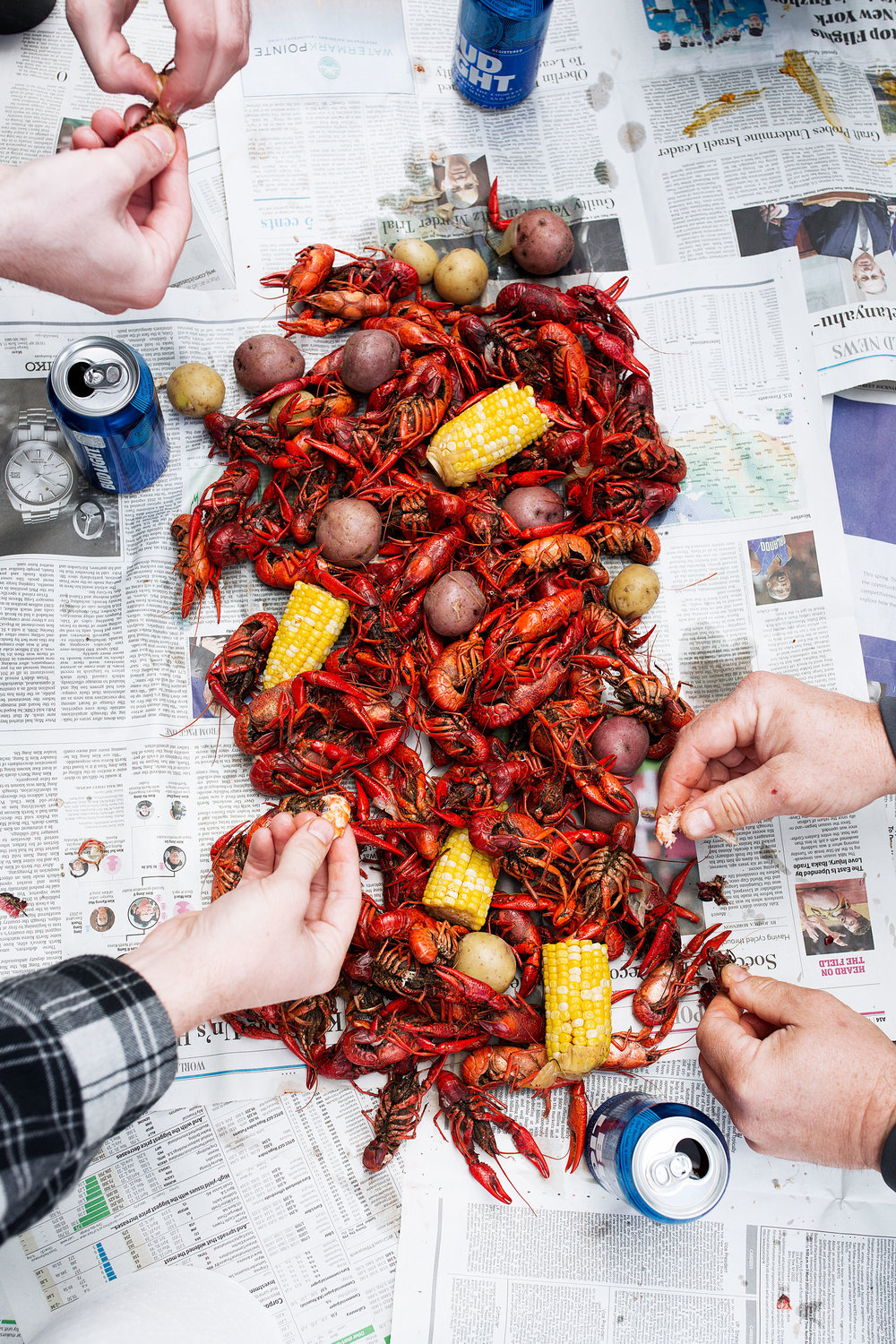 traditional southern crawfish boil recipe with corn and potatoes spread on newspaper