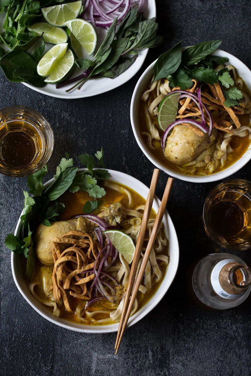 chicken khao soi recipe garnished with herbs and crispy chow mein noodles from cooking with cocktail rings
