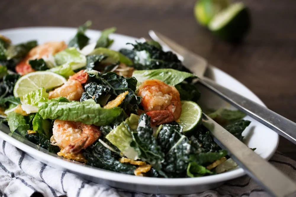 side view Kale Caesar Salad with Lime and Crispy Shrimp recipe from cooking with cocktail rings