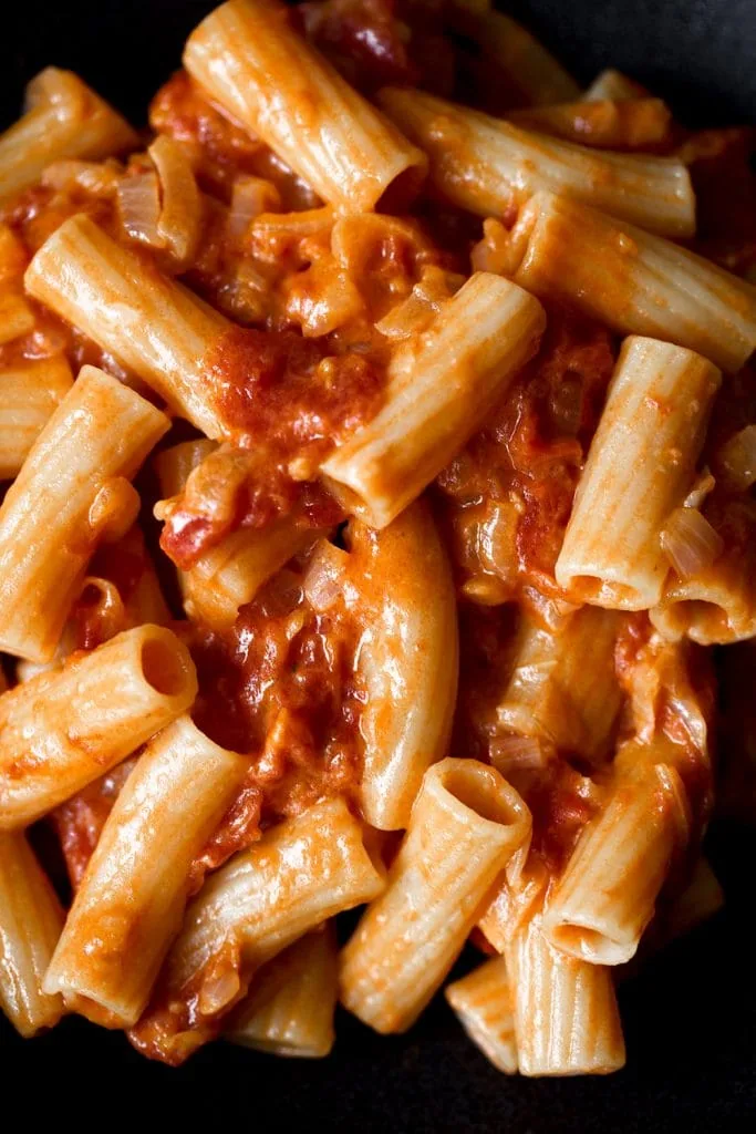 spicy rigatoni in bright orange red tomato sauce closeup