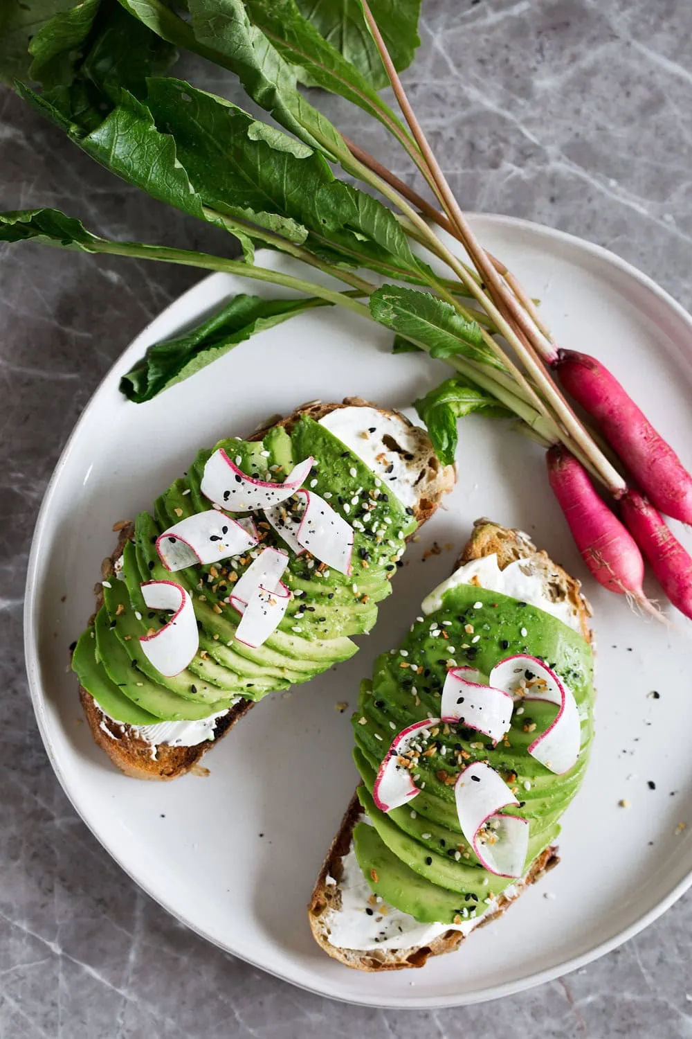 loaded everything bagel spice avocado toasts with cream cheese and shaved breakfast radish