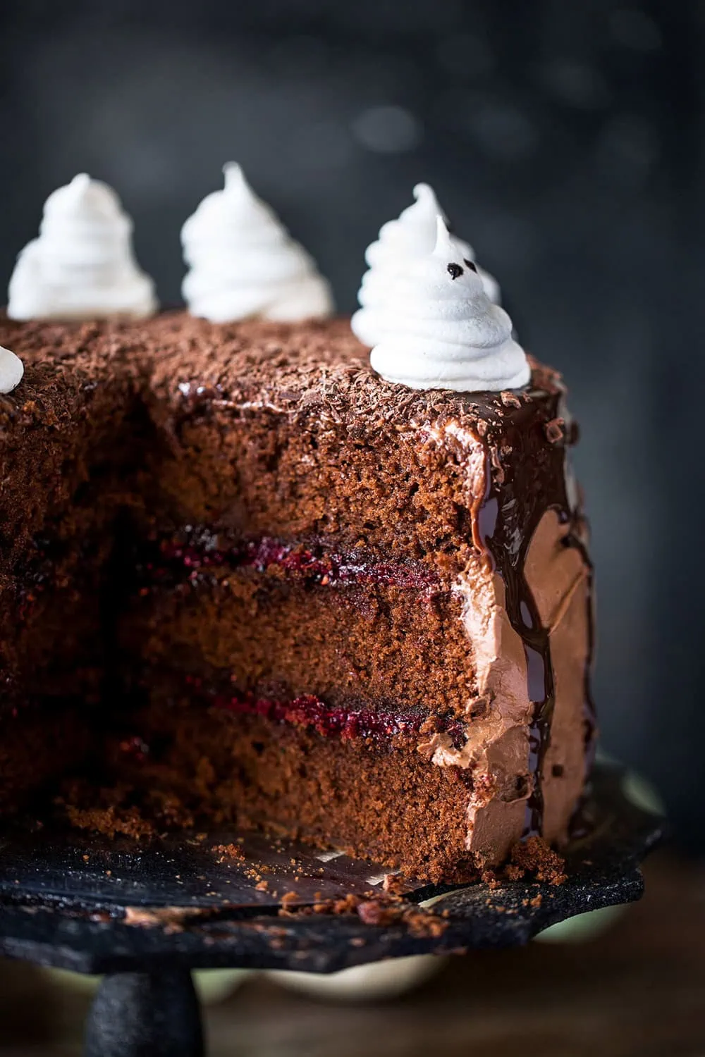 Dark Chocolate halloween Cake with Raspberry Filling, Chocolate Ganache and Meringue Ghosts cut cake