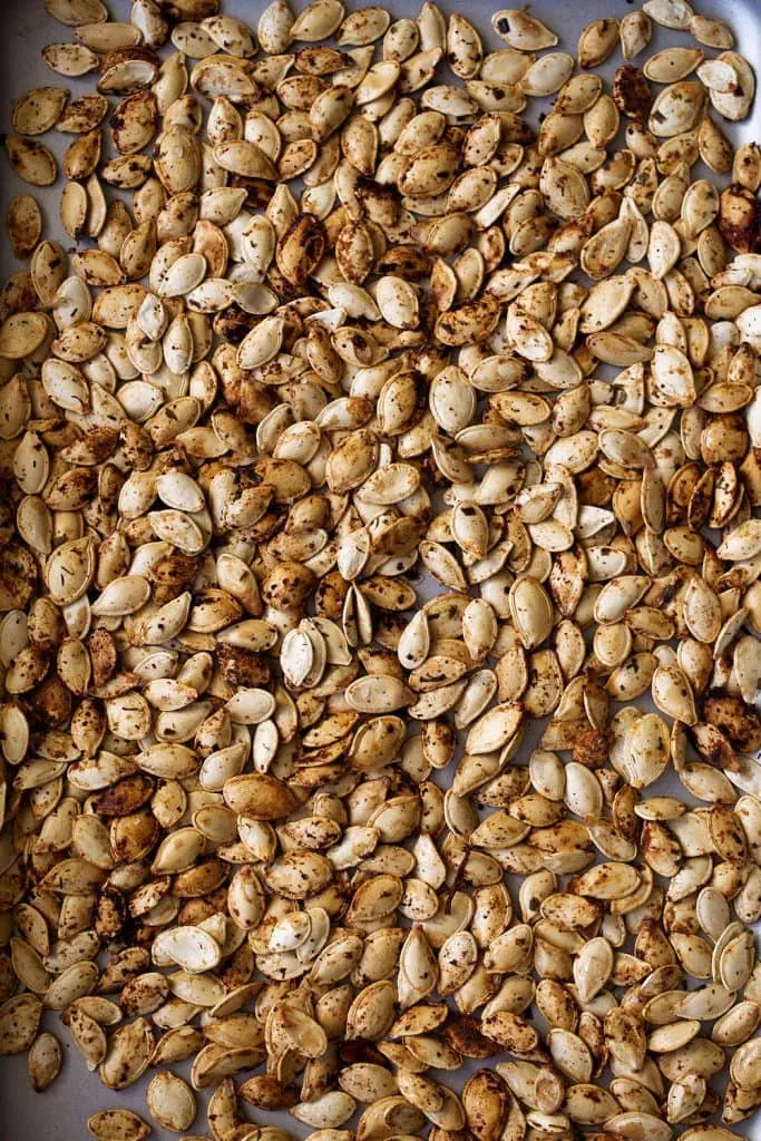 roasted pumpkin seeds spread on baking sheet with homemade ranch seasoning