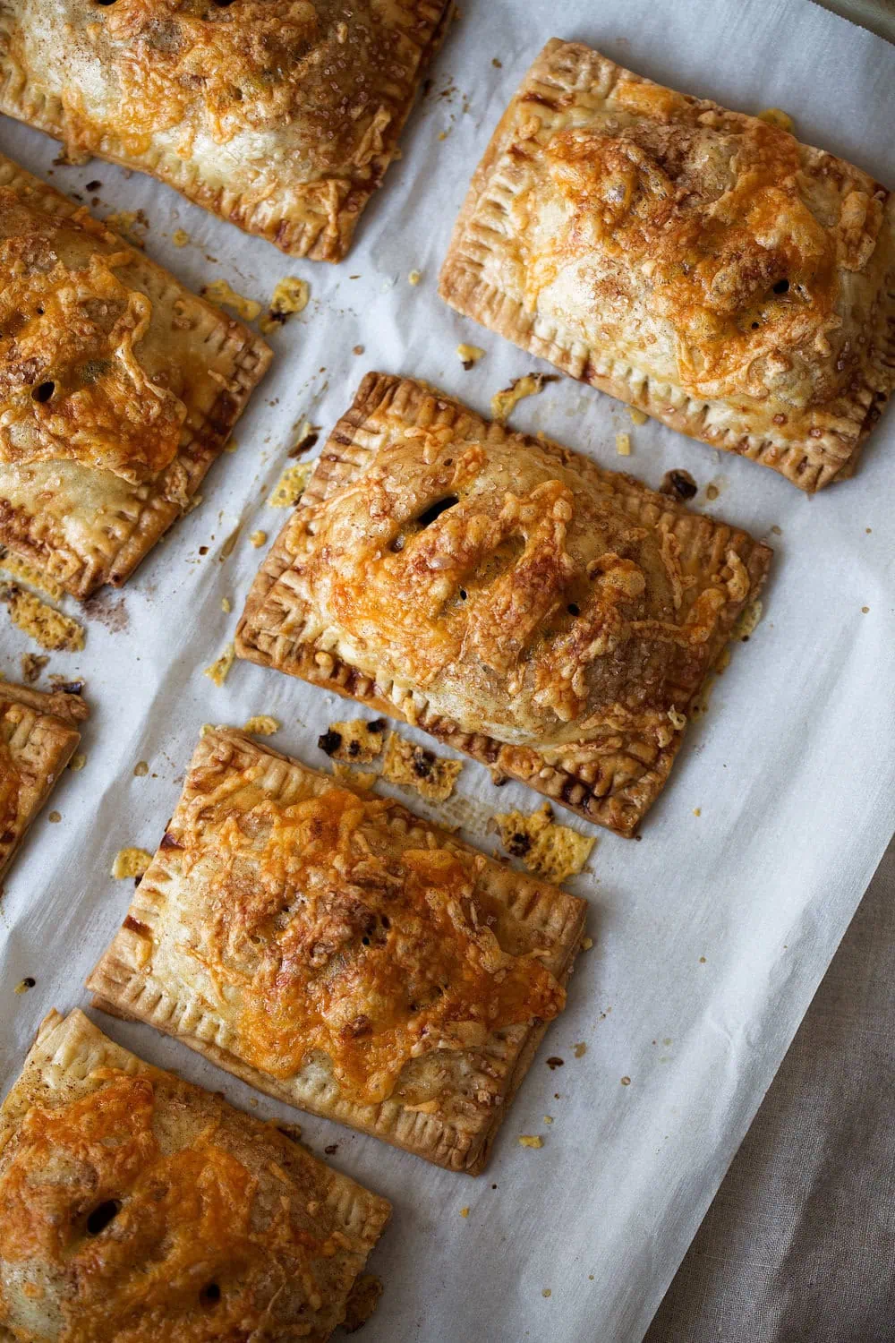 apple cheddar hand pies on parchment paper