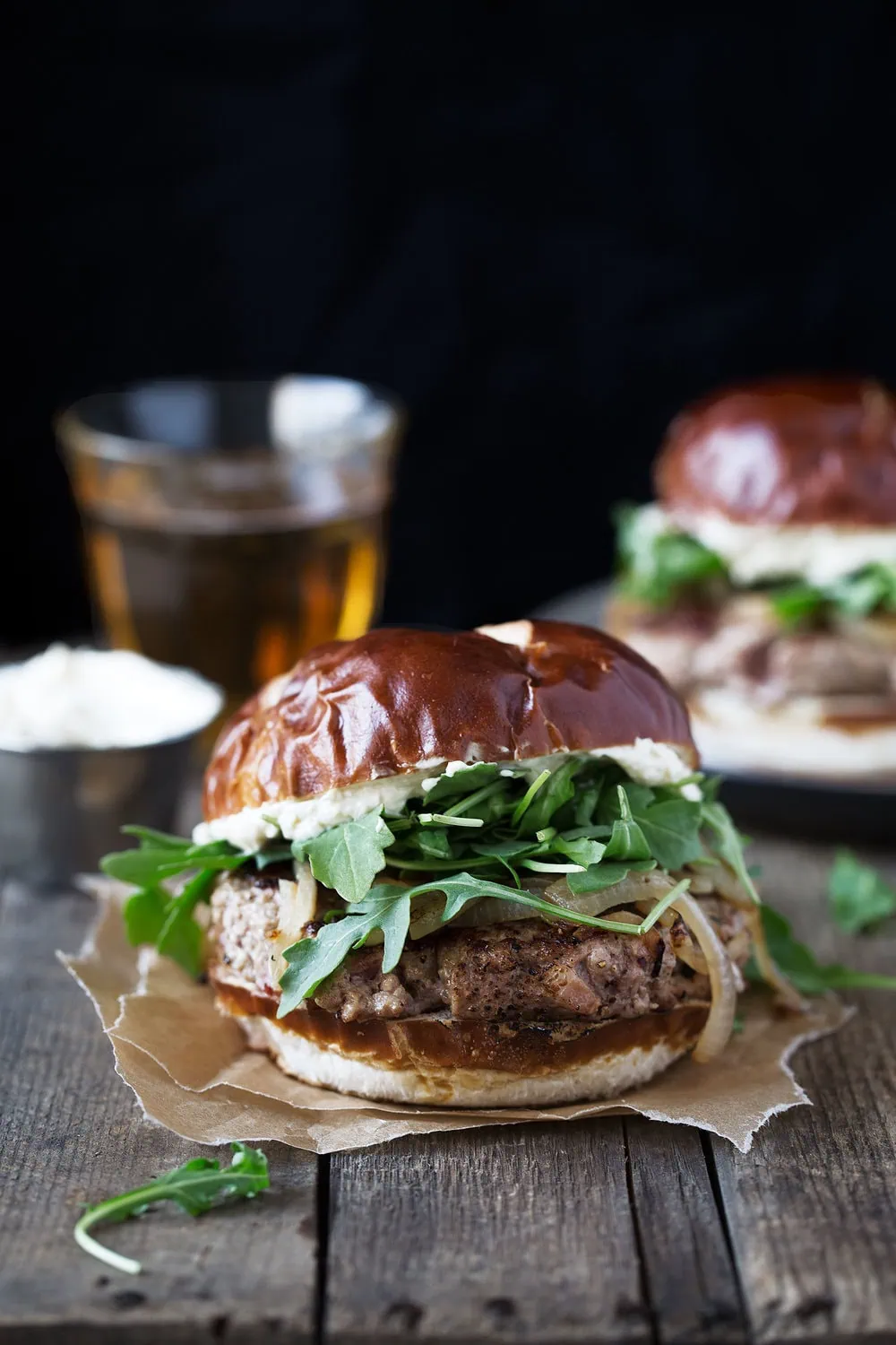 oktoberfest burger on pretzel bun with arugula and grilled onions