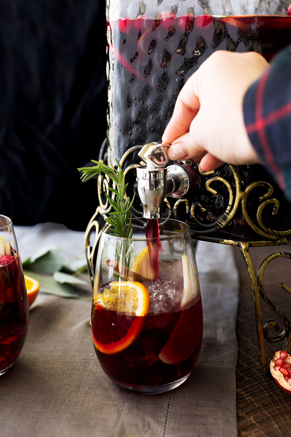 winter red sangria in large jug with rosemary garnish