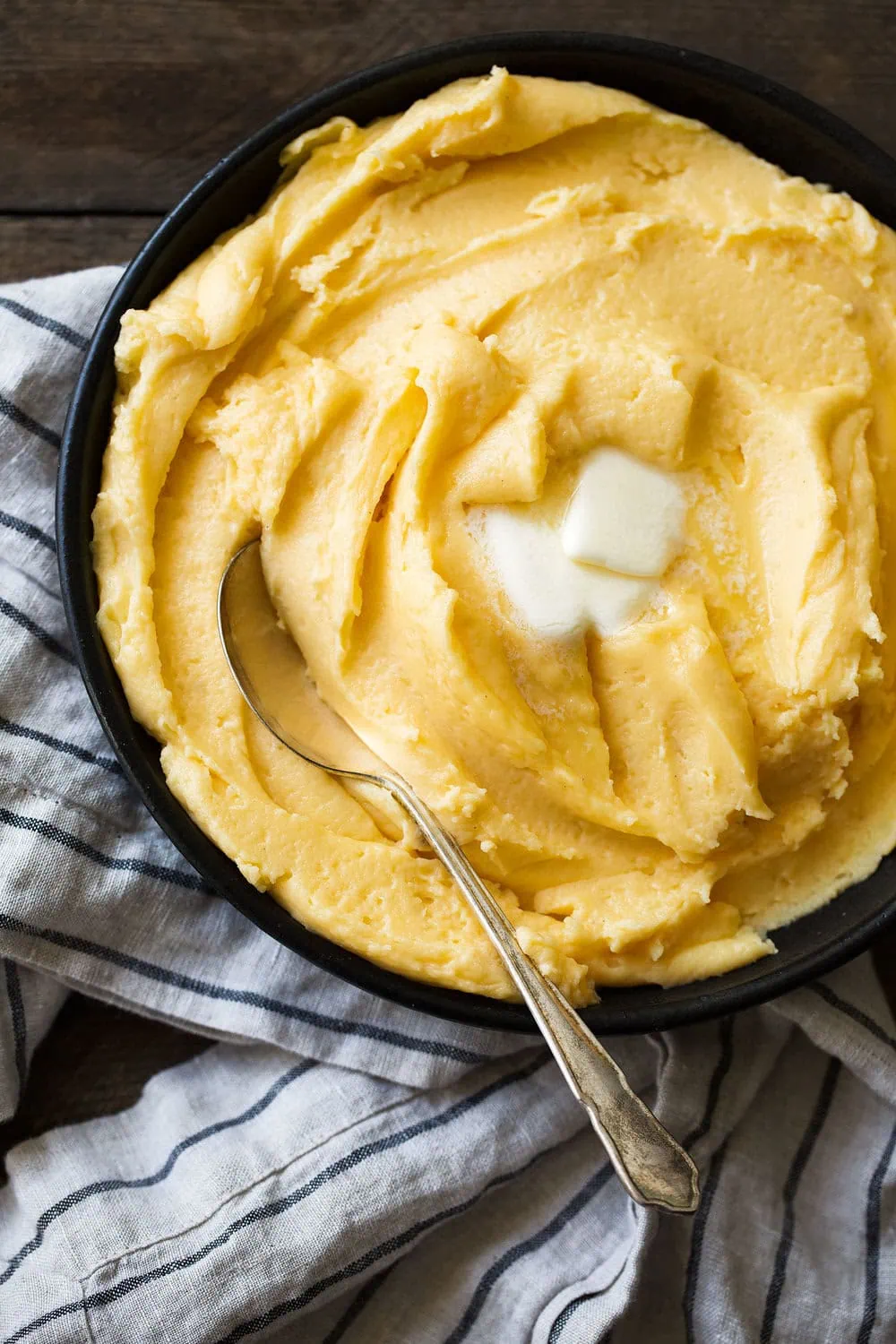whipped cheddar mashed potatoes with pats of butter 