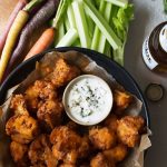 Crispy Buffalo Cauliflower Bites with blue cheese dressing, carrots and celery.