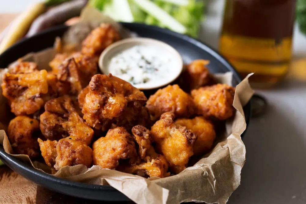 Crispy Buffalo Cauliflower Bites cooking with cocktail rings side view