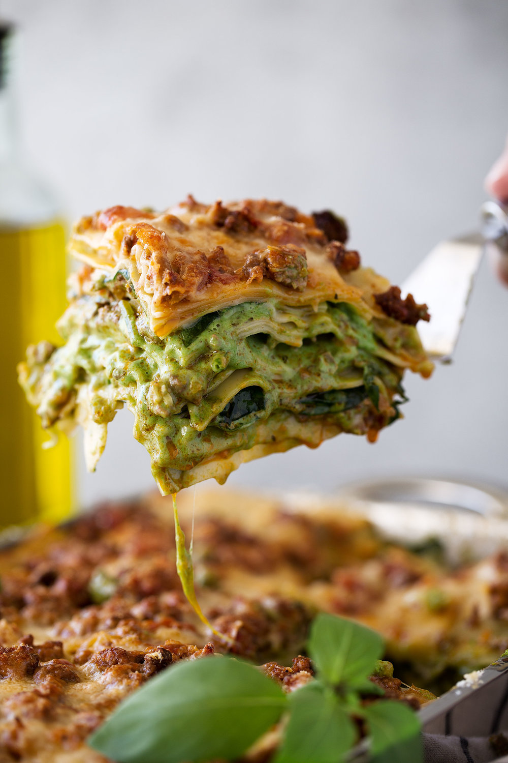 layers of lasagna verde slice with bolognese meat sauce with spinach bechamel sauce and cheese