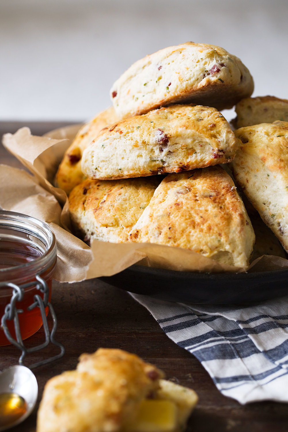 Four cheese and sausage savory scones with hot sauce glaze stacked in bowl