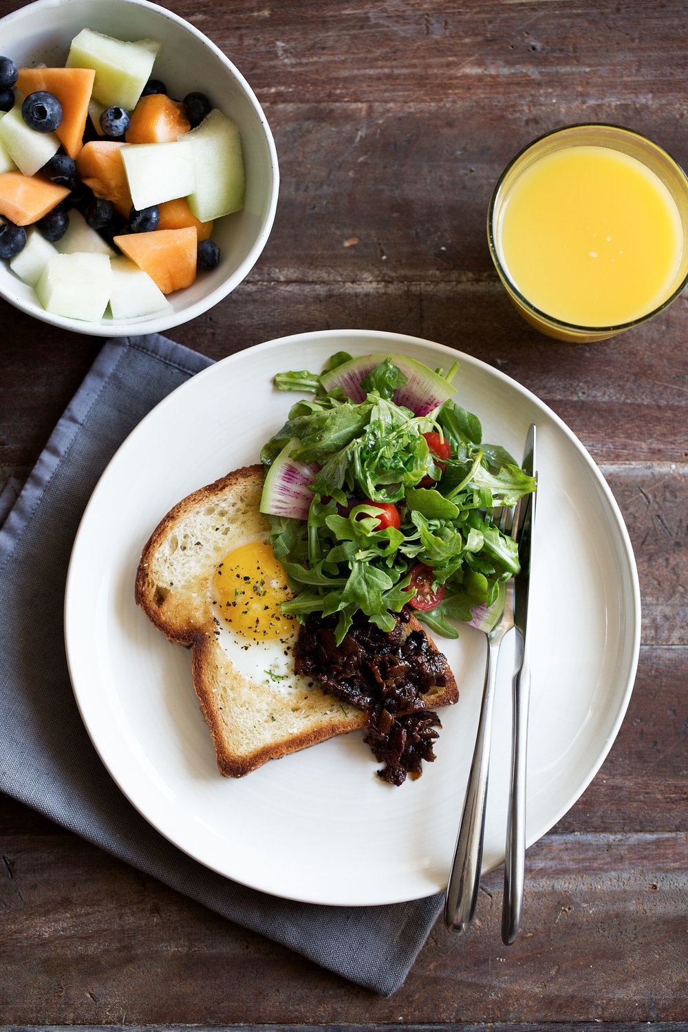 egg in a hole brioche toast with bacon onion jam and arugula salad 