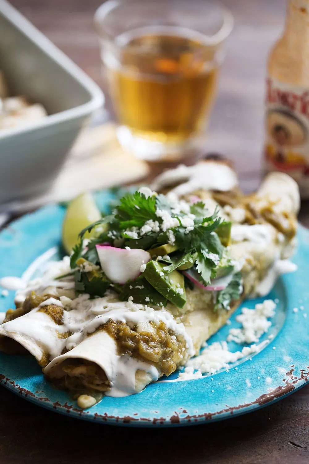 cheesy chicken & sweet corn enchilada verdes garnished with avocado radish, cilantro and lime