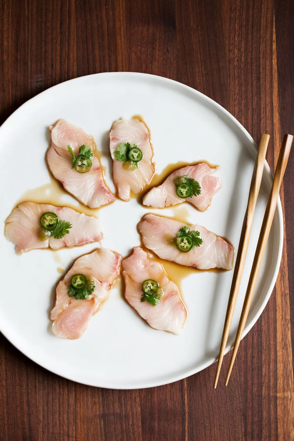 yellowtail sashimi with serrano cilantro and ponzu on white plate