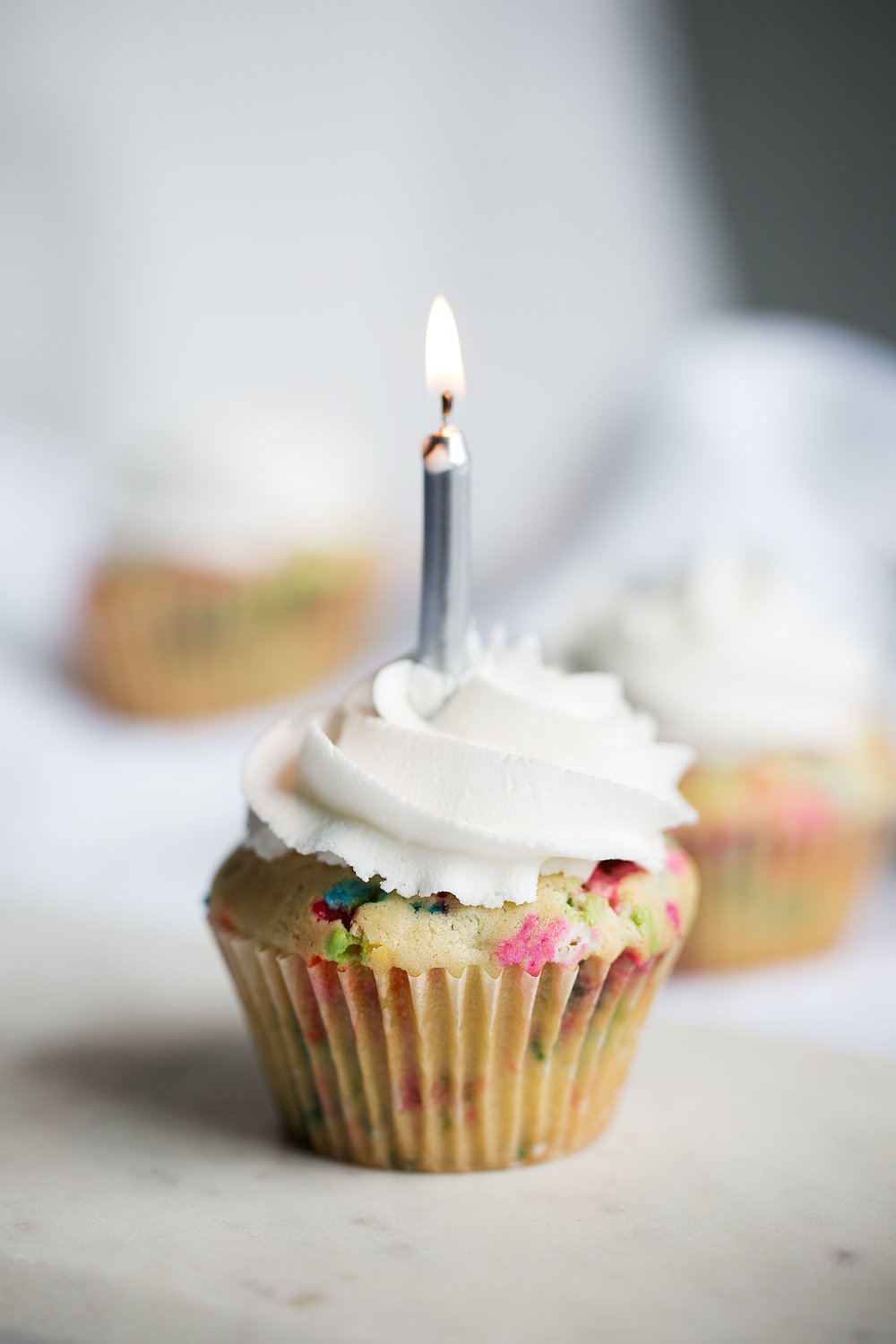 birthday cupcakes with candle and vanilla icing 
