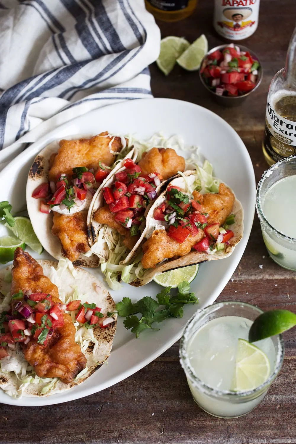 Golden brown beer battered fish tacos in corn tortillas with creamy herb yogurt sauce