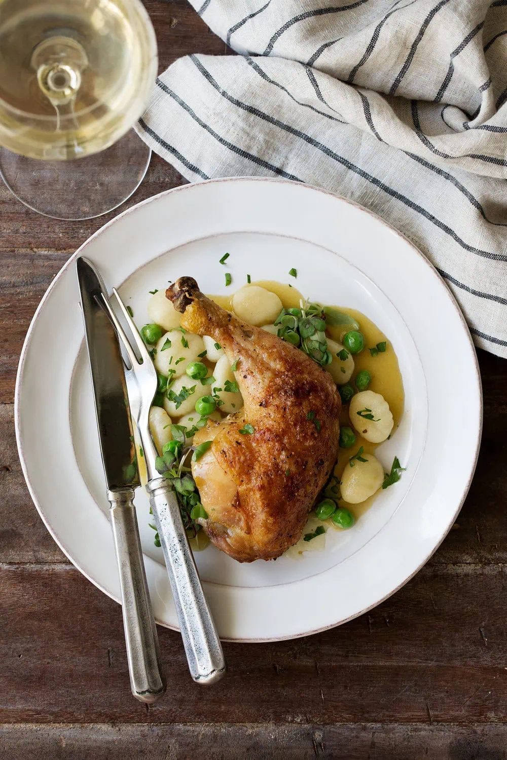 roast chicken leg and gnocchi "dumplings" with peas on plate