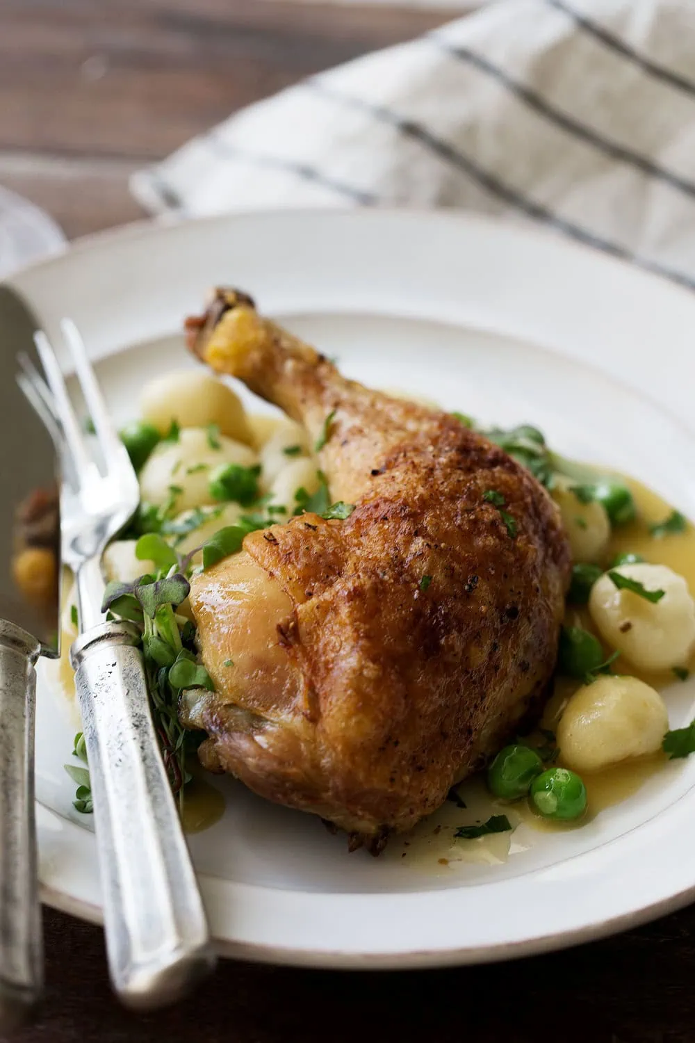 crispy roast chicken leg and gnocchi dumplings with peas