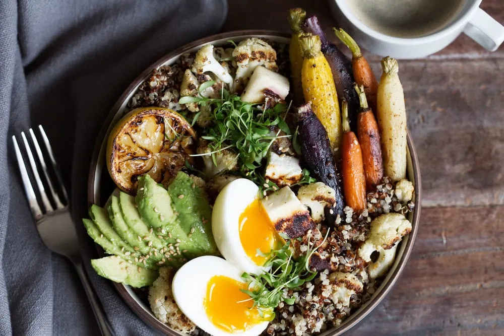 farmer's market grain bowl with halloumi, quinoa halved soft-boiled egg