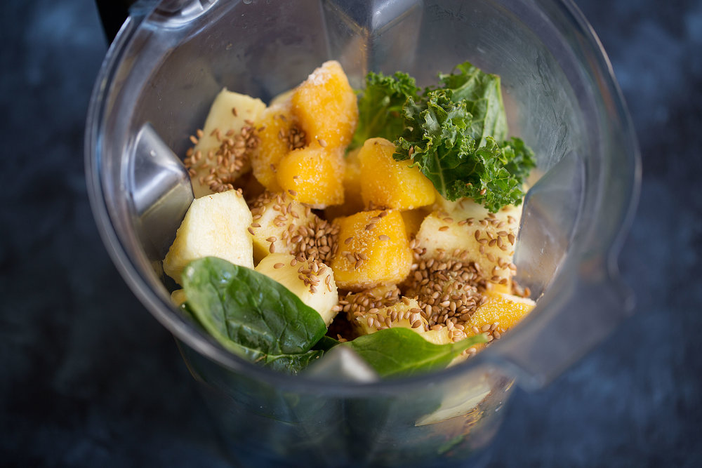 tropical green smoothie with mango pineapple kale in blender