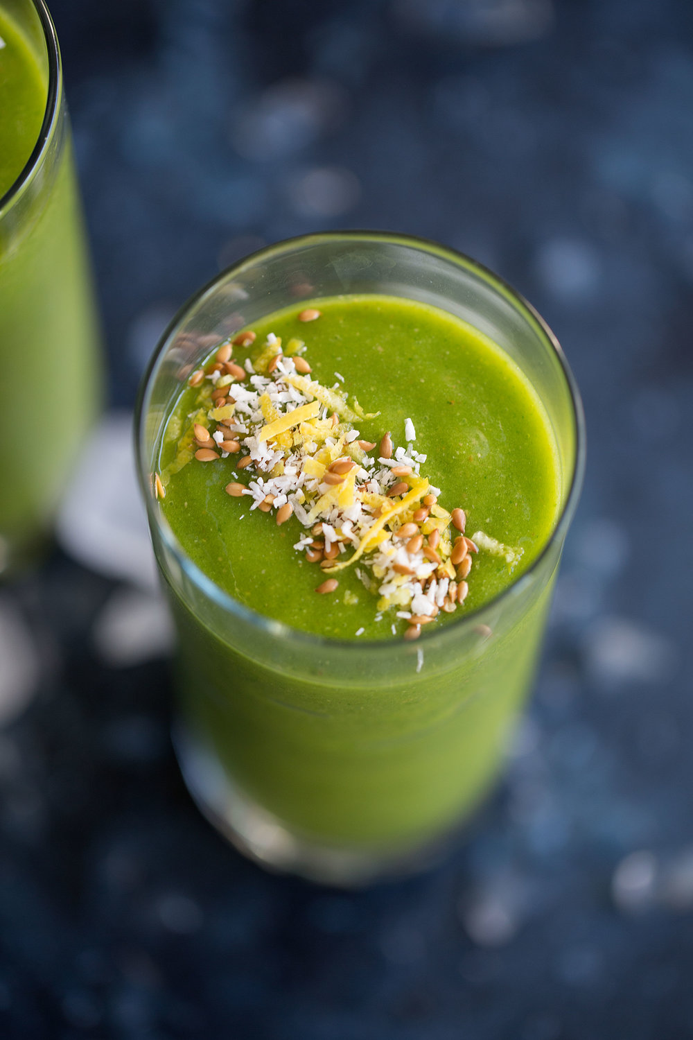 closeup green smoothie with shredded coconut, flax seeds and lemon zest