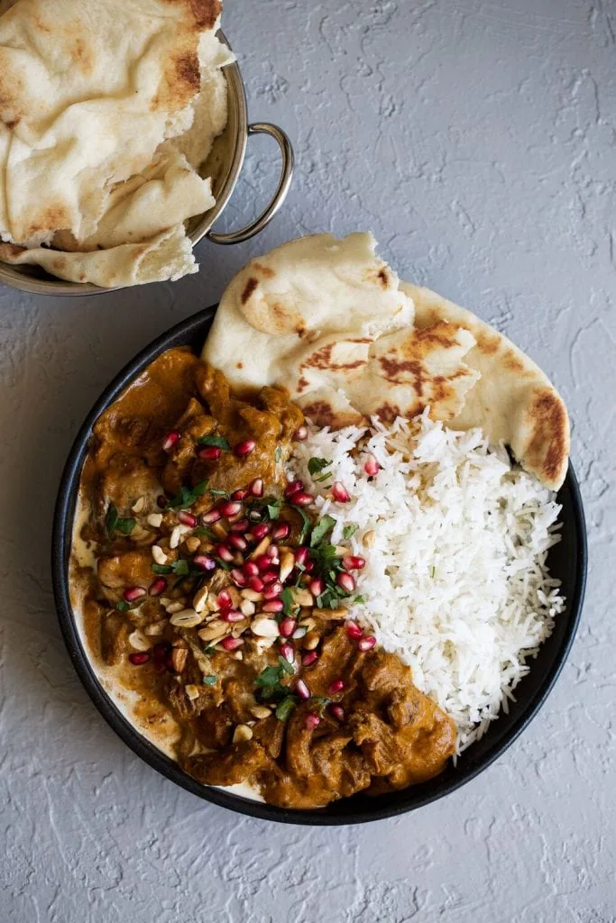 Lamb Korma and side of naan and basmati rice in bowl.