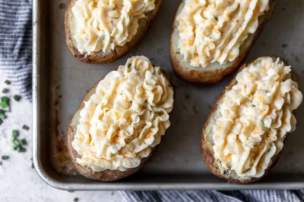 baked potatoes piped with cheesy mashed potato filling