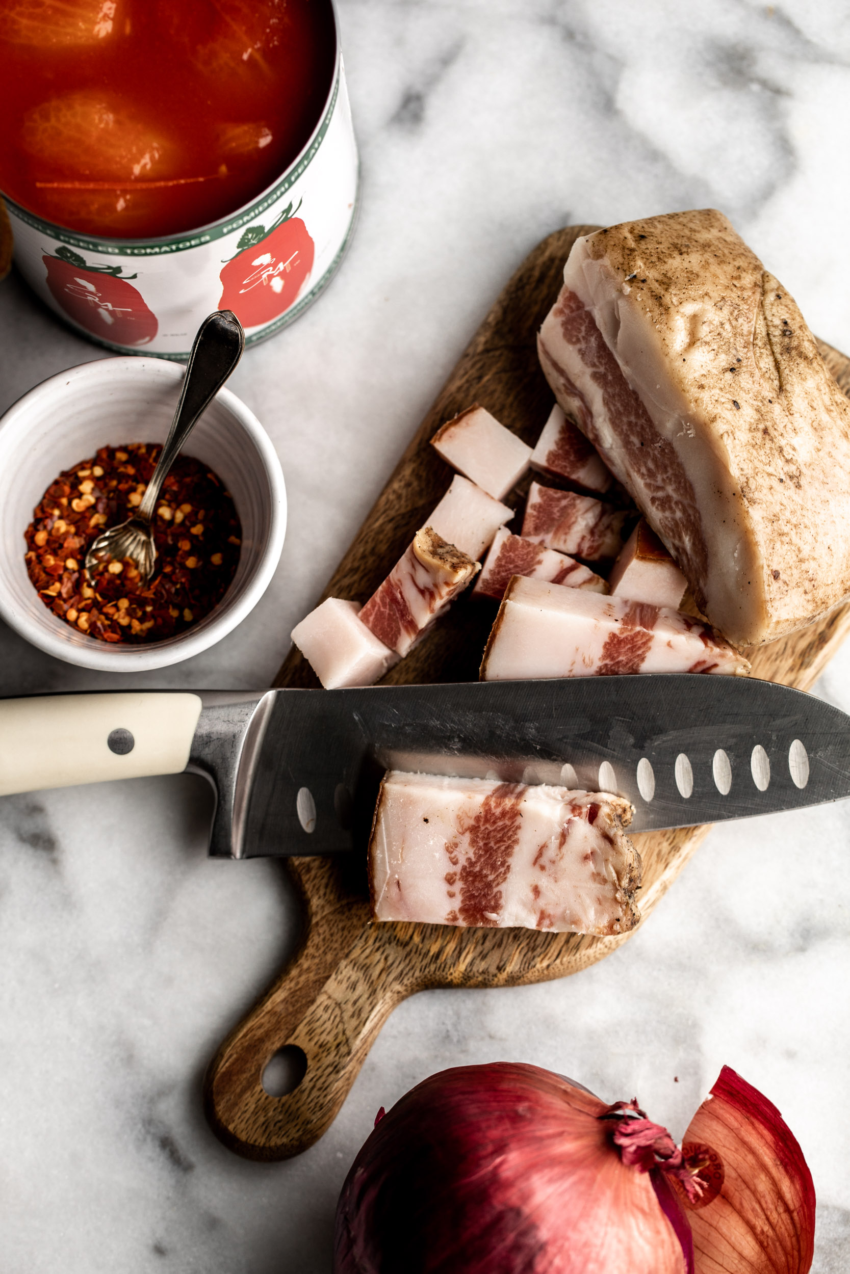 guanciale sliced on cutting board 