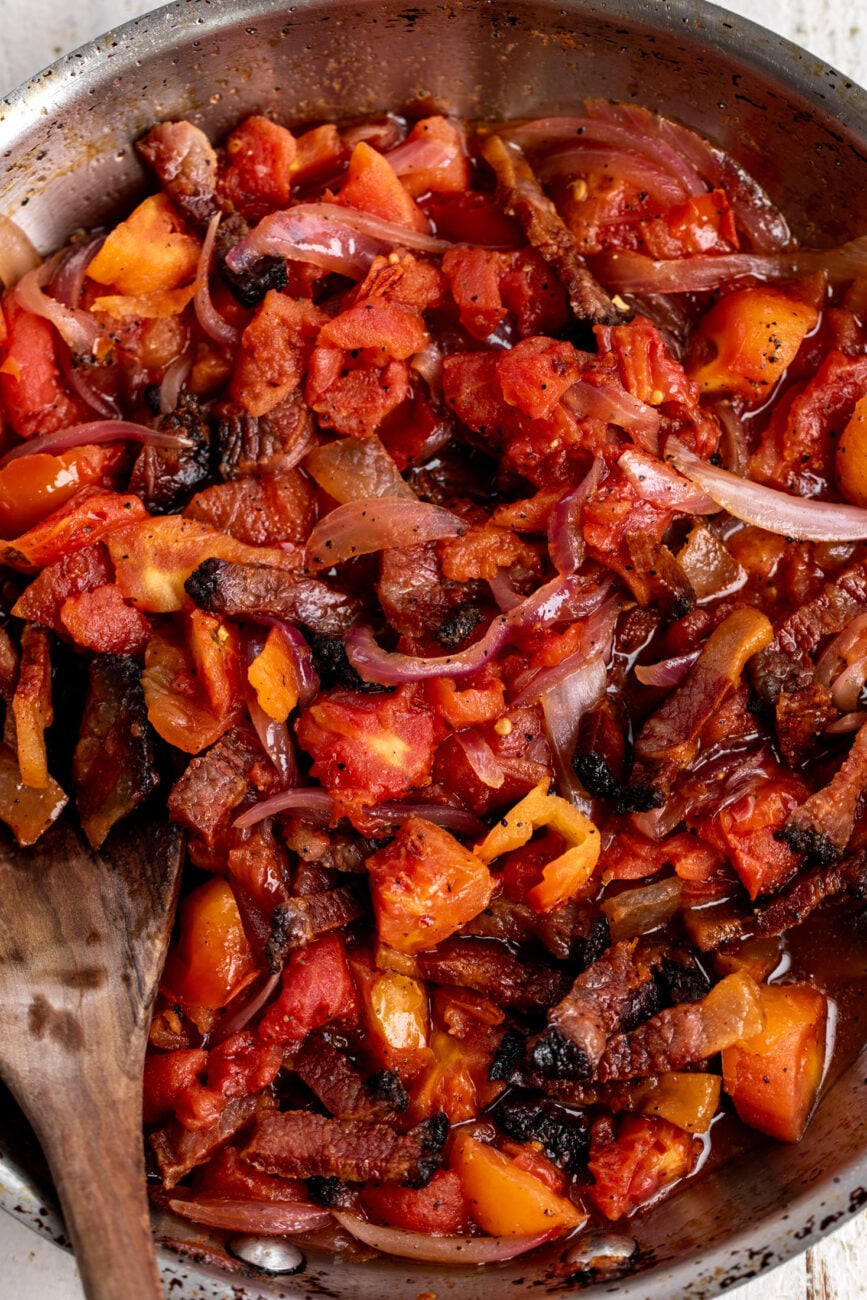 guanciale, chopped peeled tomatoes and onions in pan.