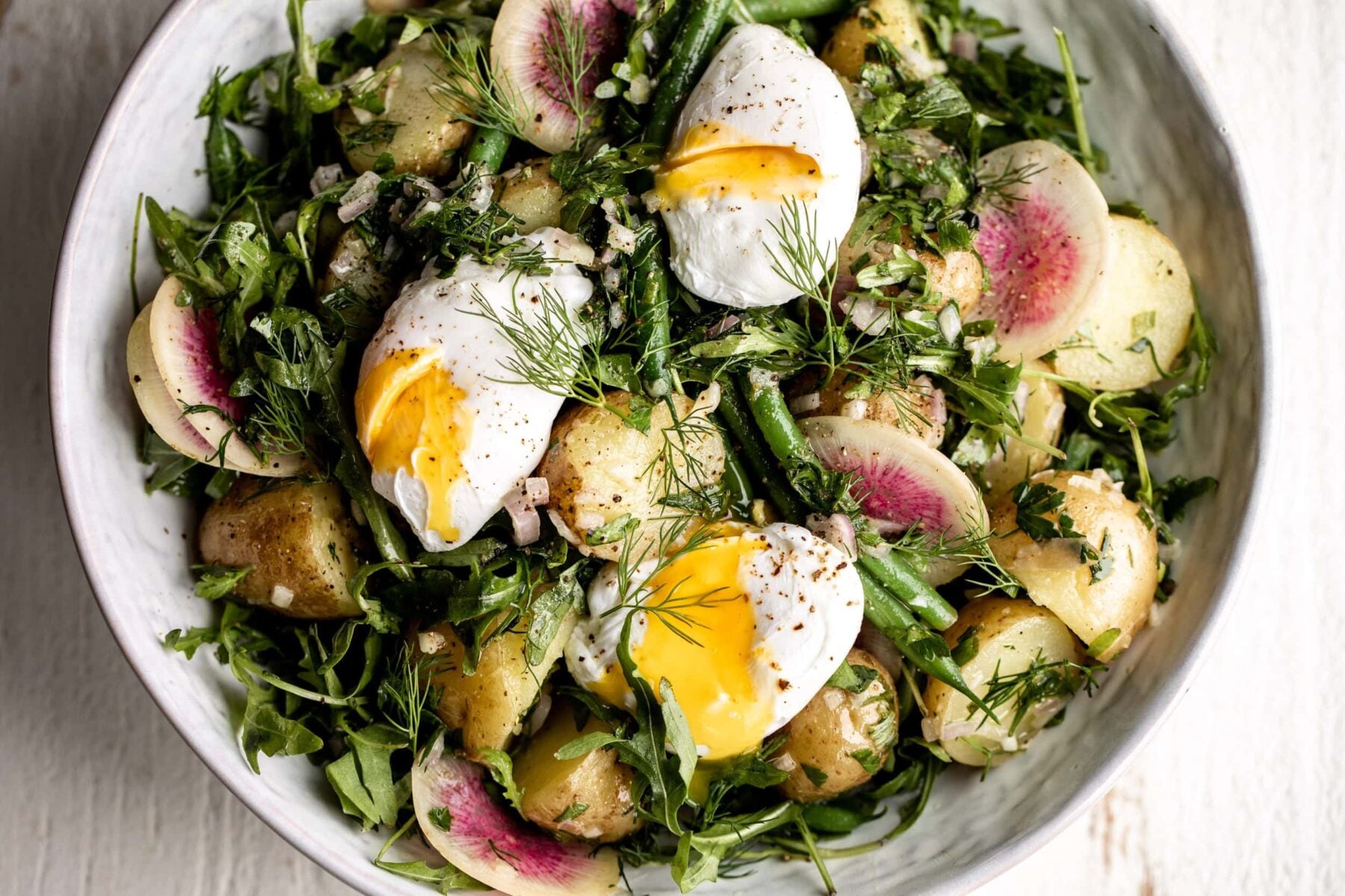 French Potato Salad with Green Beans and poached eggs with watermelon radish.