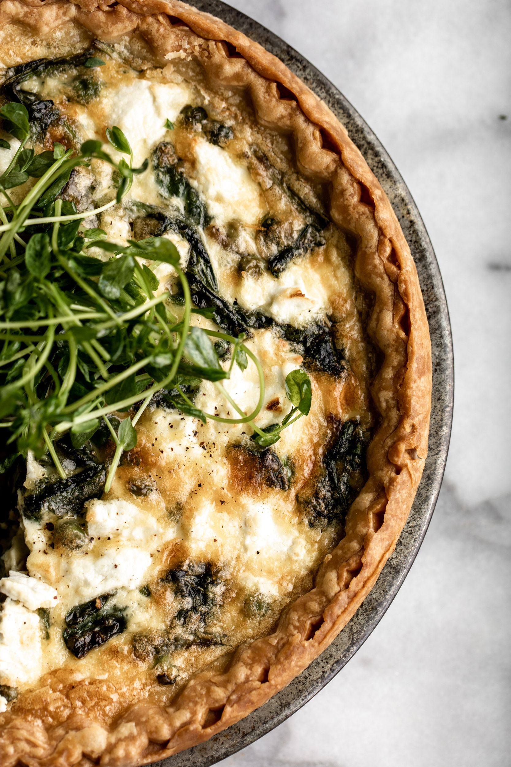 spring vegetable quiche recipe garnished with pea shoots