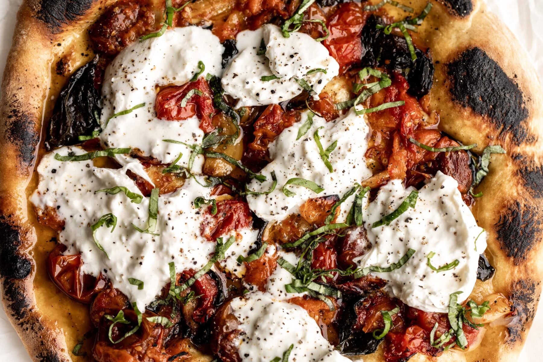 confit tomato pizza with basil and burrata cheese.