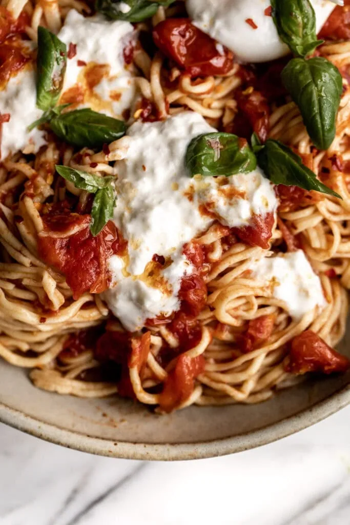 Homemade Spaghetti with Confit Cherry Tomatoes, Burrata & Basil in stone bowl