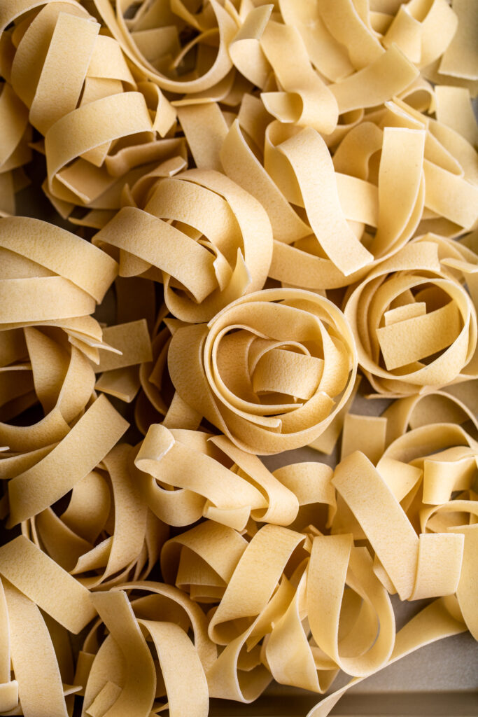 closeup dried pappardelle pasta nests for Creamy Tomato & Bacon Pasta