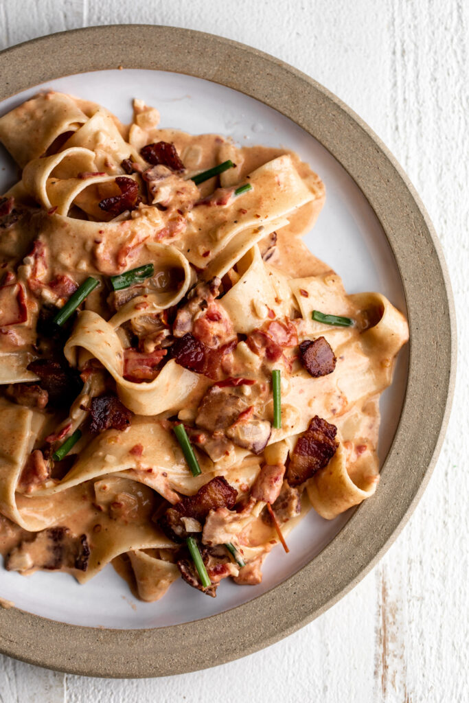 easy tomato and bacon pasta recipe on ceramic plate