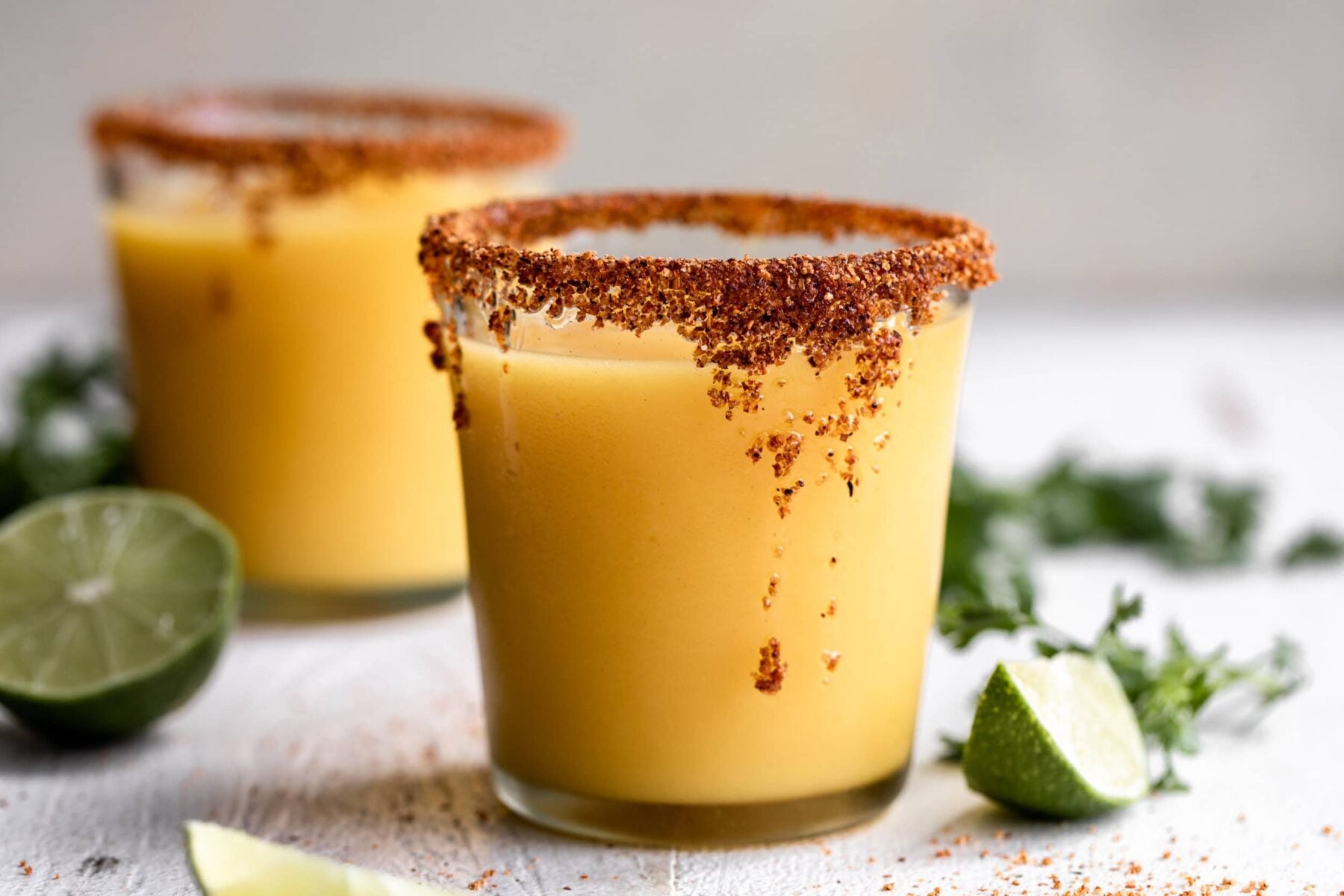 frozen mango margaritas with tajin and honey rim.